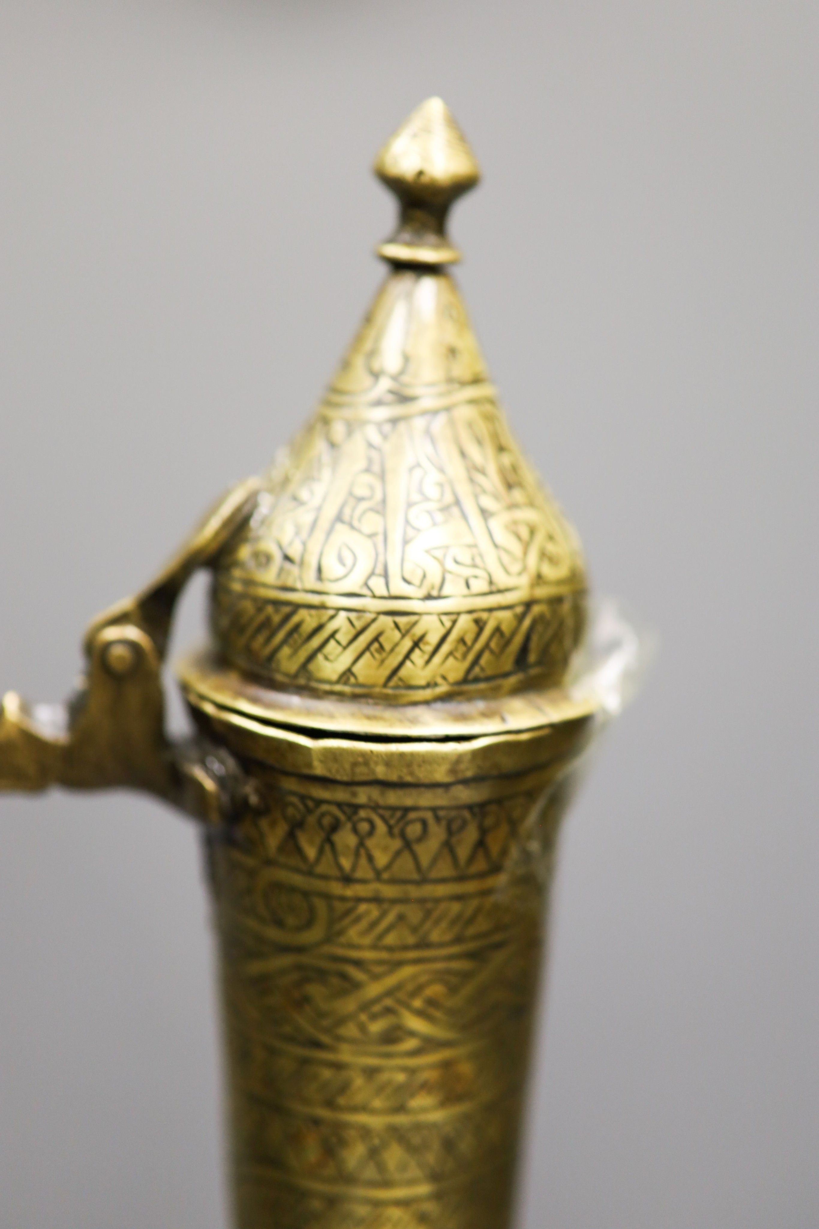 A Persian engraved brass ewer and Middle-eastern horn and white metal priming shot flask 57cm